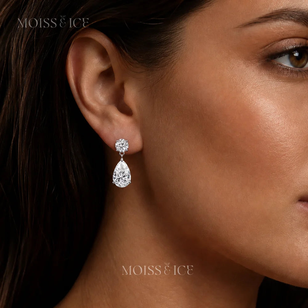 A close-up of a woman's ear wearing a single Moiss & Ice tear drop shaped moissanite drop earring