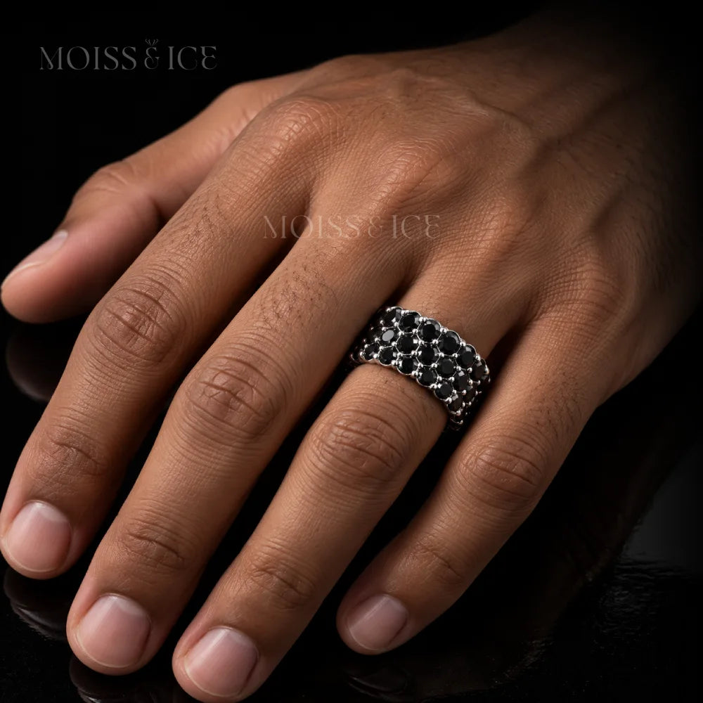 Man wearing a black moissanite ring with 3 rows of black moissanite round brilliant cut in white gold. The Kaamuk Black by Moiss Ice Canada